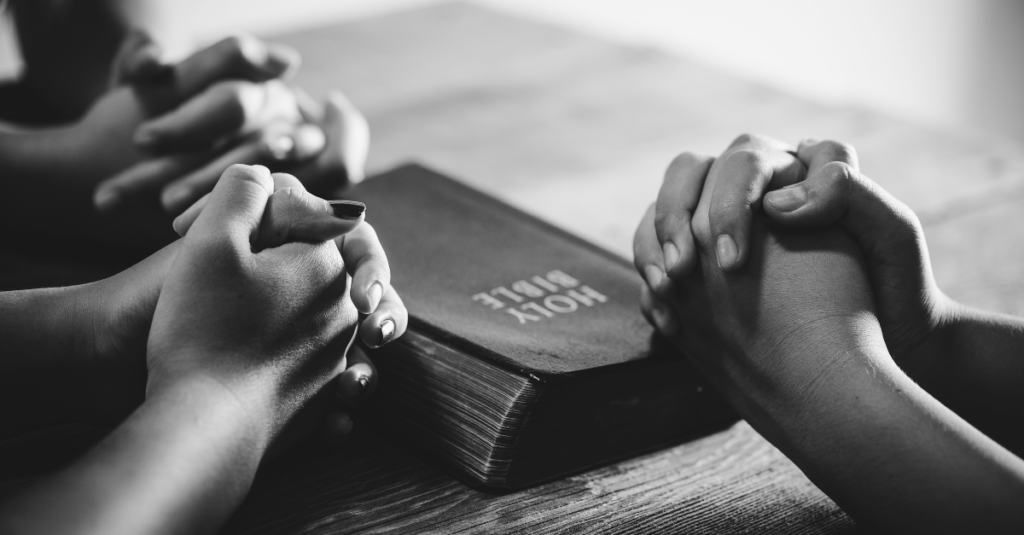 Picture of Bible with people praying